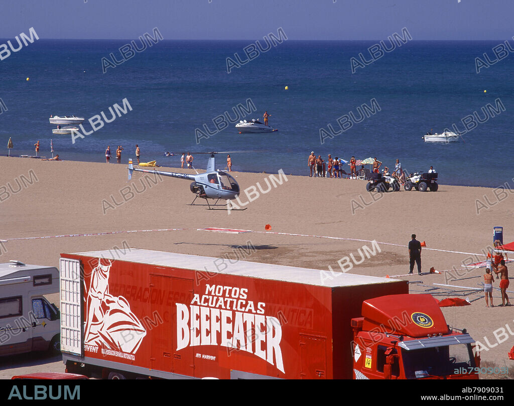 HELICOPTERO ATERRIZANDO EN LA PLAYA - CAMION CON PUBLICIDAD DE GINEBRA BEEFEATER.