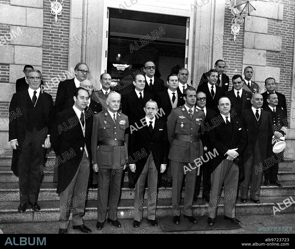 December 13, 1975. After the oath before His Majesty the King (1), the New Ministers posed with the monarch at the door of the Zarzuela palace. 2, Antonio Garrigues. 3, Juan M. villar Mir. 4, Carlos Robles Piquer. 5, José María de Areilza. 6, Félix Álvarez-Arenas. 7, Fernando de Santiago. 8, Antonio Valdes. 9, Leopoldo Calvo-Sotelo. 10, Carlos Arias. 11, Alfonso Osorio. 12, Francisco Lozano. 13, Virgilio Oñate, 14, Adolfo Suárez. 15, Adolfo Martín-Gainero. 16, Manuel Fraga. 17, Rodolfo Martín Villa. 18, Carlos Franco. 19, José Solis. 20, Carlos Pérez Bricio. 21, Gabriel whistles Da Veiga.