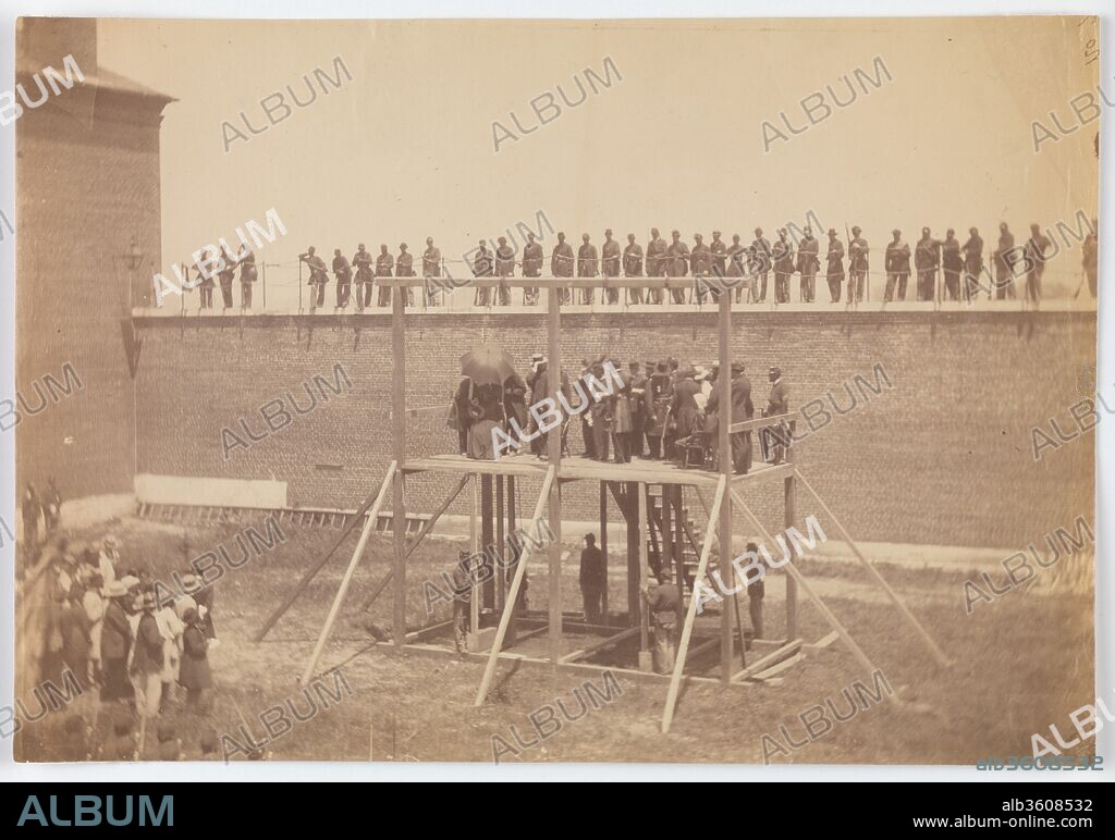 Execution of the Conspirators. Artist: Alexander Gardner (American, Glasgow, Scotland 1821-1882 Washington, D.C.). Dimensions: Image: 16.8 x 24.2 cm (6 5/8 x 9 1/2 in.). Date: July 7, 1865.
Alexander Gardner's intimate involvement in the events following President Lincoln's assassination would have challenged even the most experienced twentieth-century photojournalist. In just short of four months, Gardner documented in hundreds of portraits and views one of the most complex national news stories in American history. The U.S. Secret Service provided Gardner unlimited access to individuals and places unavailable to any other photographer. Free to retain all but one of his negatives-a portrait of Booth's corpse-Gardner attempted to sell carte-de-visite and large-format prints of the whole picture story. America, still wounded from the four-year war, was less than interested.
The photographs of the execution of Mary Surratt, Lewis Paine, David Herold, and George Atzerodt on July 7, 1865, were, however, highly sought after by early collectors of Civil War ephemera beginning in the 1880s. This photograph shows the final preparations on the scaffolding in the yard of the Old Arsenal Prison. The day was extremely hot and a parasol shades Mary Surratt, seated at the far left of the stage. (She would become the first woman in America to be hanged.) Two soldiers stationed beneath the stage grasp the narrow beams that hold up the gallows trapdoors. The soldier on the left would later admit he had just vomited, from heat and tension. Only one noose is visible, slightly to the left of Surratt; the other three nooses moved during the exposure and are registered by the camera only as faint blurs. Members of the clergy crowd the stage and provide final counsel to the conspirators. A private audience of invited guests stands at the lower left. Minutes after Gardner's exposure, the conspirators were tied and blindfolded and the order was given to knock out the support beams.