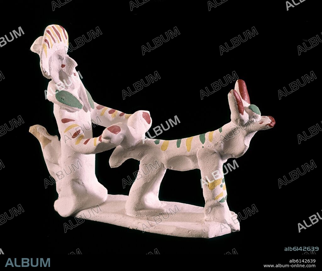 PITO DE ARCILLA (SIURELL) BAÑADO EN CAL Y PINTADO - FIGURA DE ANCIANO Y PERRO.