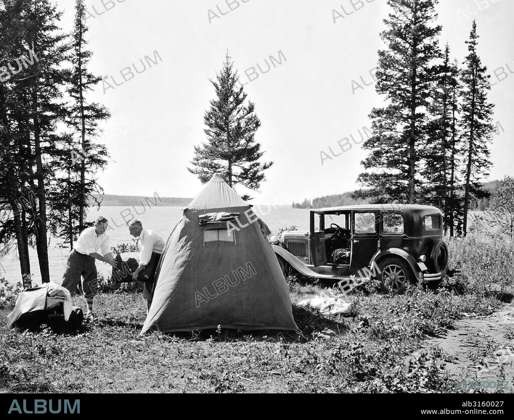Wasagaming, Manitoba, Canada: c. 1931 Two men setting up camp on the shore of Clear Lake in Riding Mountain National Park.