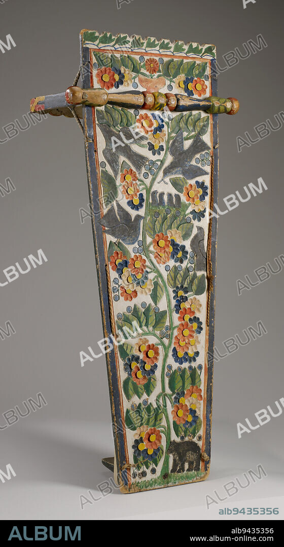 Cradleboard, c.1850-1880, 32 1/4 x 13 1/4 x 14 1/4 in. (81.92 x 33.66 x 36.2 cm), Wood, pigment, string, United States, 19th century, The Kahnawake (Mohawk) of the Haudenosaunee (Iroquois Confederacy) create cradleboards from large planks of wood to which they attach protective bows that go over the child's head. Some examples have footrests to provide additional support. The backs are decorated with elaborate painted carvings. In the 17th century, the Kahnawake lived in an area surrounded by French-Canadian settlers, whose folk art influenced traditional Kahnawake art. Some scholars believe that the carving of some cradleboards was created by French-Canadian folk artists, but the iconography has a consistent theme related to the Kanien'gehaga traditional worldview. There is usually a carved flowering tree that may reference the Sky World; the tree often has a mother bird feeding her young and represents the relationship between the cosmos and the Kahnawake people.