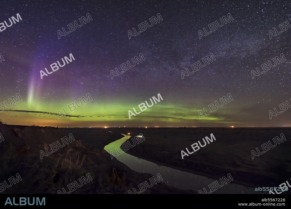 A faint aurora along the northern horizon and the summer Milky Way rising in the northeast, over the winding Red Deer River north of Drumheller, Alberta, Canada, on May 5/6, 2018.