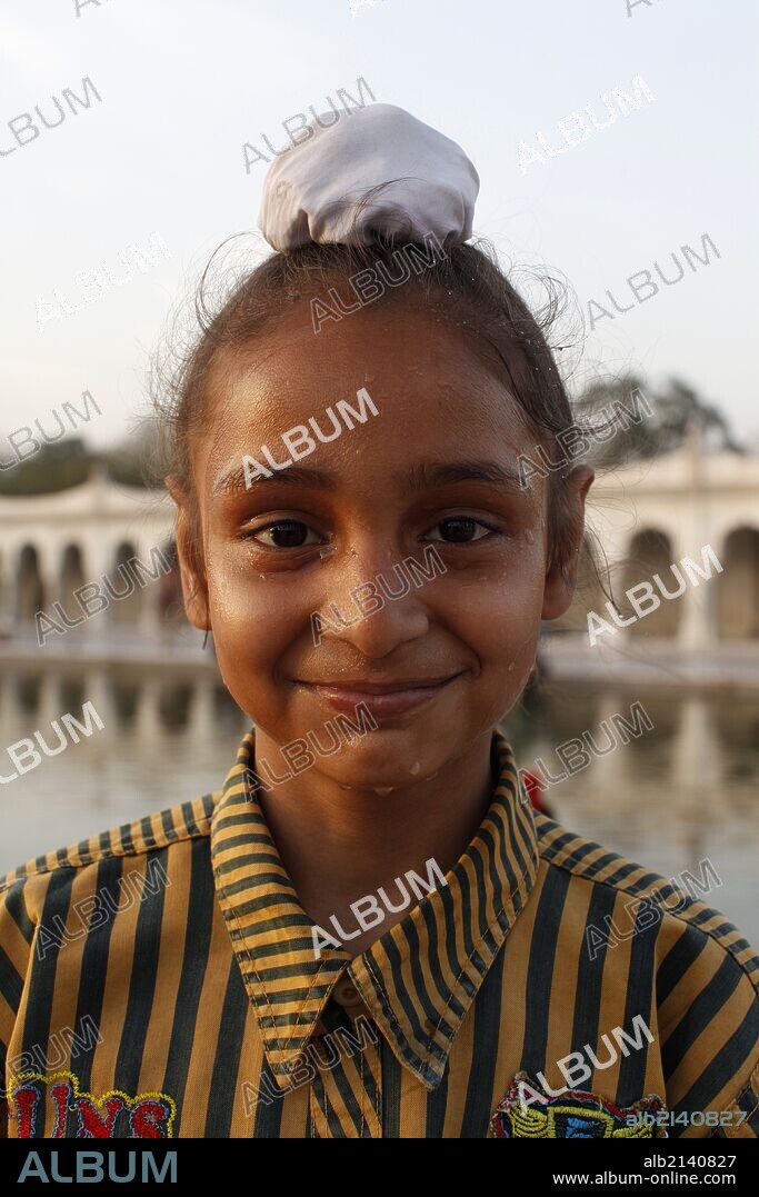 Bangla Sahib Gurdwara, New Delhi Young sikh wearing a rishi knot cover.
