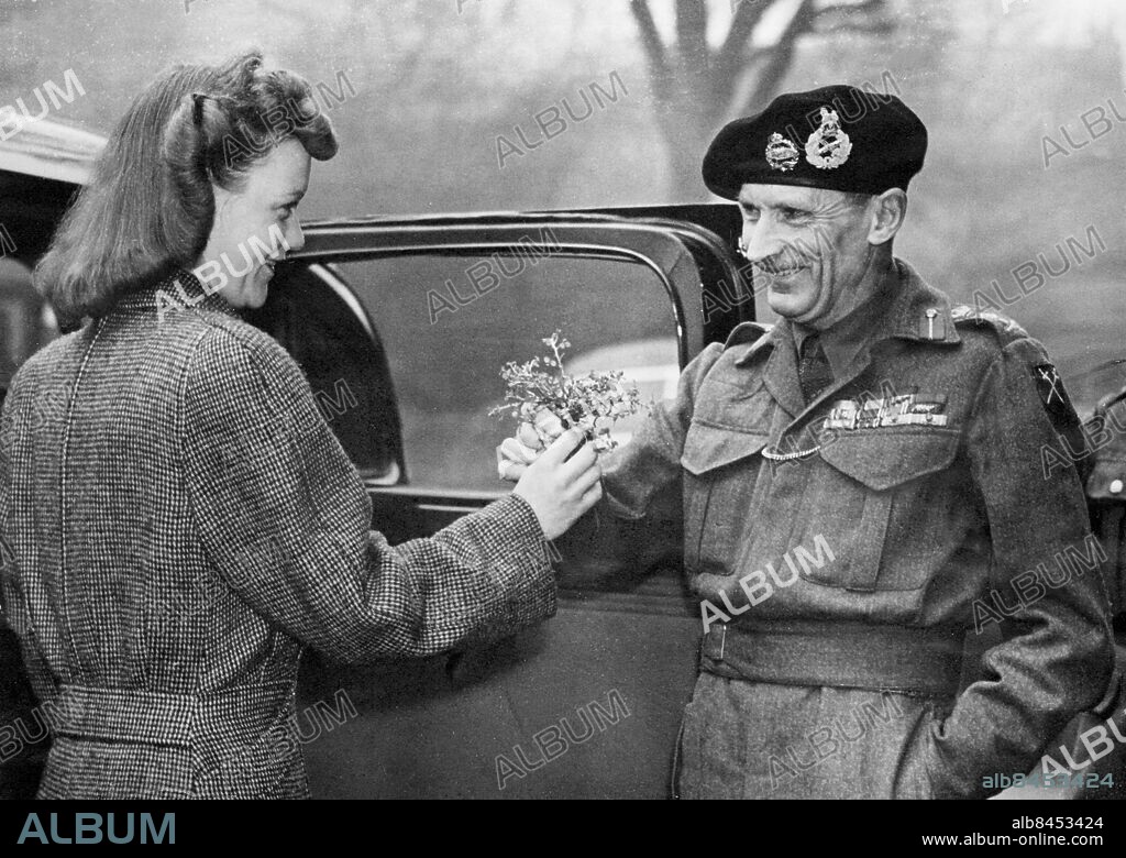 Orig. bildtext... ST. PATRICK'S DAY IN LONDON MONTY GETS HIS SHAMROCK. 17-3-44 Photo shows: Gen. Montgomery being presented with a shamrock by Miss Comber of Greenford, on leaving his hotel. Orig. bildtext... PÅ ST. PATRICKSDAGEN får general Montgomery Irlands nationalblomma av en beundrarinna. 3-44 Anm. B Montgomery, 1887-1976, brittisk militär, fältmarskalk 1944. Saint Patrick's Day, Irlands nationaldag 17 mars. Basker Buketter Handen i fickan Gåvor Profiler Symboler Överlämna CD647 persons: BERNARD MONTGOMERY sites: STORBRITANNIEN;LONDON.