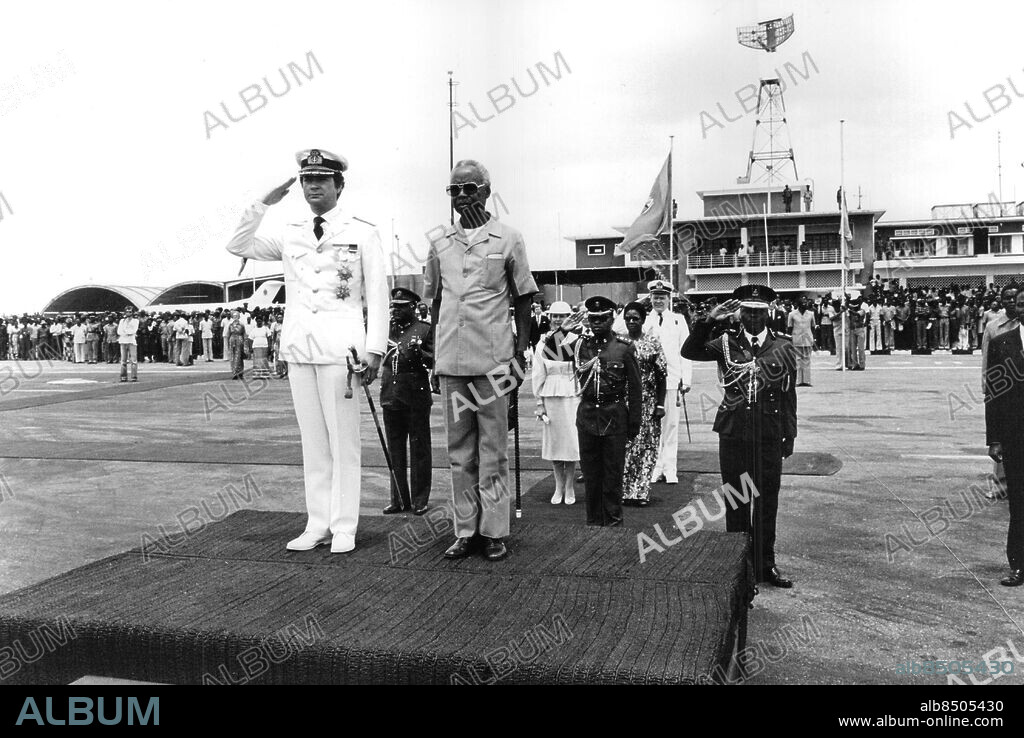 Zanzibar 1981-02-01. Kung Carl XVI Gustaf iklädd vit safariuniform tillsammans med lokala politiker under statsbesöket i Tanzania. Drottning Silvia i bakgrunden. Foto: Leif R Jansson / Svenskt Pressfoto / TT / kod 20360.