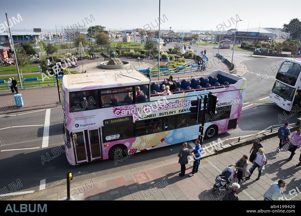 Compass Gardens, Tower Esplanade, Skegness, Lincolnshire, 2017. General view looking towards the gardens from the west, with an open-topped sight-seer's bus passing in the foreground.