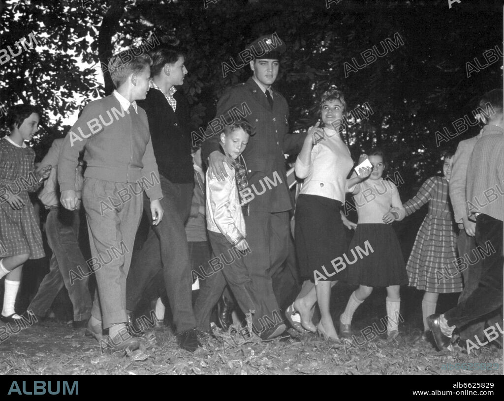 Elvis Presley goes for a walk with his fans in the park of Bad Homburg on the 5th of October in 1958. To the delight of his fans, the American Rock'n Roll singer was stationed in Friedberg (Hesse) in the context of his military service in the US Army in the 1950s. 05/10/1958