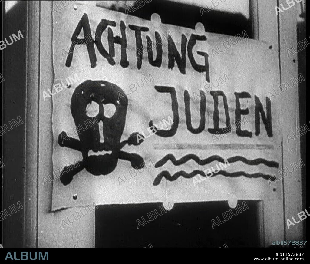 Sign Reading: 'Achtung Juden', 1933. Anti-semitic notice: "Caution/attention Jews".  'Once again, in the long history of the world, agony for the Jews'. From "Time To Remember -  The Time Of The Monster", 1933  (Reel 4); a documentary film about events of 1933, rise of Roosevelt and Hitler.
