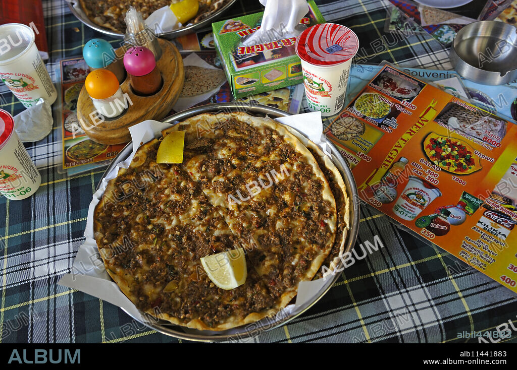 Lahmacun, a thin piece of dough topped with minced meat, served with than (Ayran), a kind of yogurt, at the Mer Taghe restaurant, Yerevan, Armenia, Eurasia.