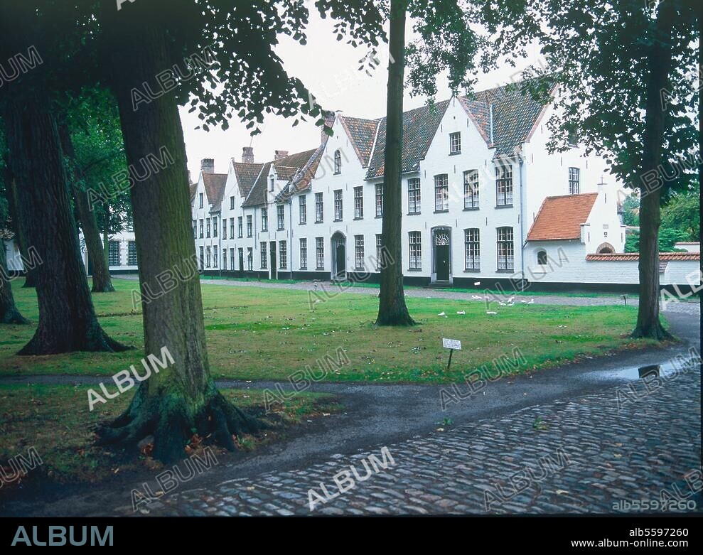 Brügge (Belgien), Begijnhof (Beginenhof; um 1230 von Johanna v. Konstantinopel, Gräfin von Flandern gestiftet; 17./18. Jh. umgeb.). Teilansicht: Hausfassaden um den baumbestandenen, begrünten Innenhof. Foto, undat.