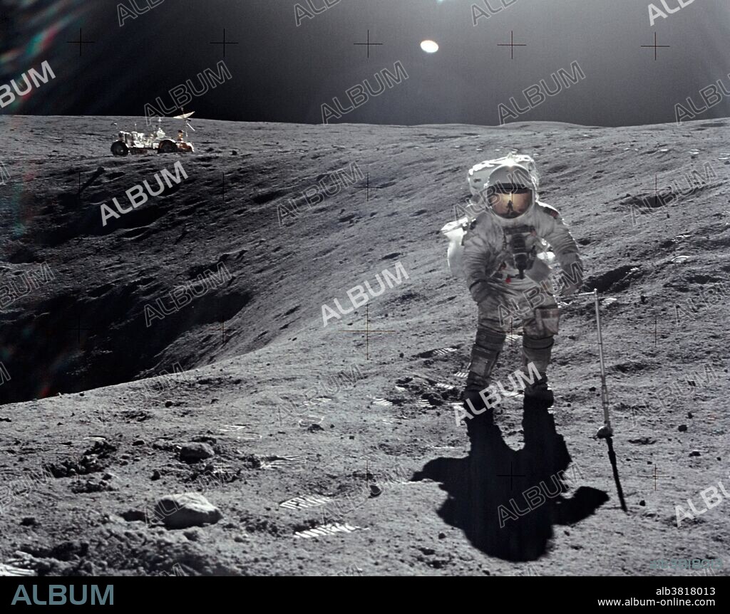 Astronaut Charles M. Duke Jr., lunar module pilot, is photographed collecting lunar samples at Station No. 1, during the first Apollo 16 extravehicular activity at the Descartes landing site. This picture, looking eastward, was taken by astronaut John W. Young, commander. Duke is standing at the rim of Plum crater. The parked Lunar Roving Vehicle can be seen in the left background. While astronauts Young and Duke descended in the Lunar Module "Orion" to explore the Descartes highlands region of the Moon, astronaut Thomas K. Mattingly II, command module pilot, remained with the Command and Service Modules "Casper" in lunar orbit.