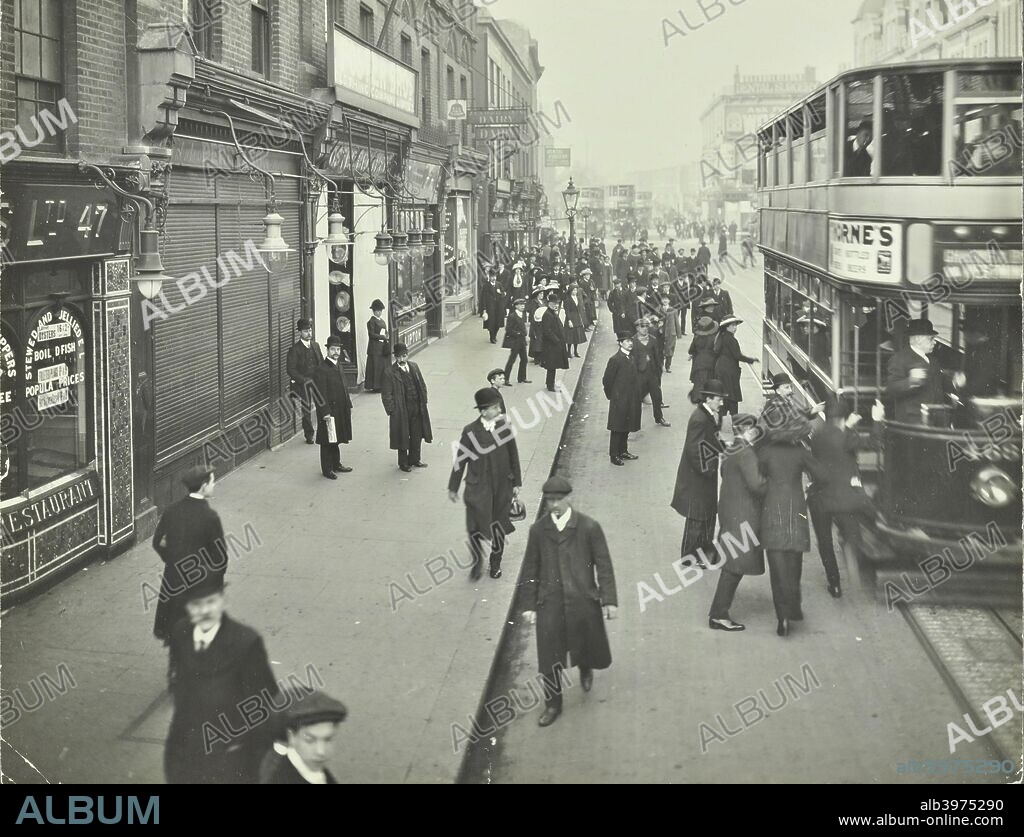 People rushing to get on a trolley bus at 7.05 am, Tooting Broadway, London, April 1912. Early-morning commuters catch a trolley bus to Charing Cross.