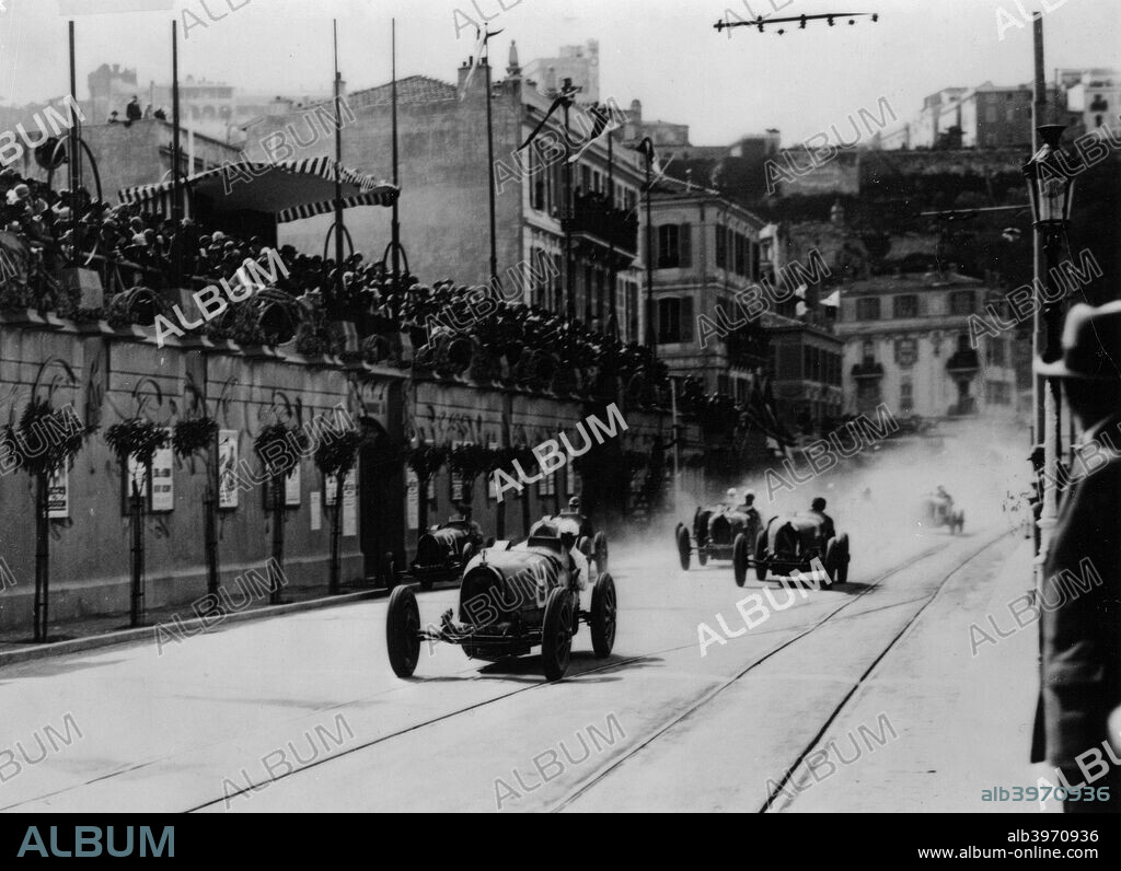 Start of the inaugural Monaco Grand Prix, 1929. Crowds watch as the cars speed along the street, led by a Bugatti. Note the tramlines. This first running of the event was won by 'W Williams' (William Grover-Williams) in a Bugatti.