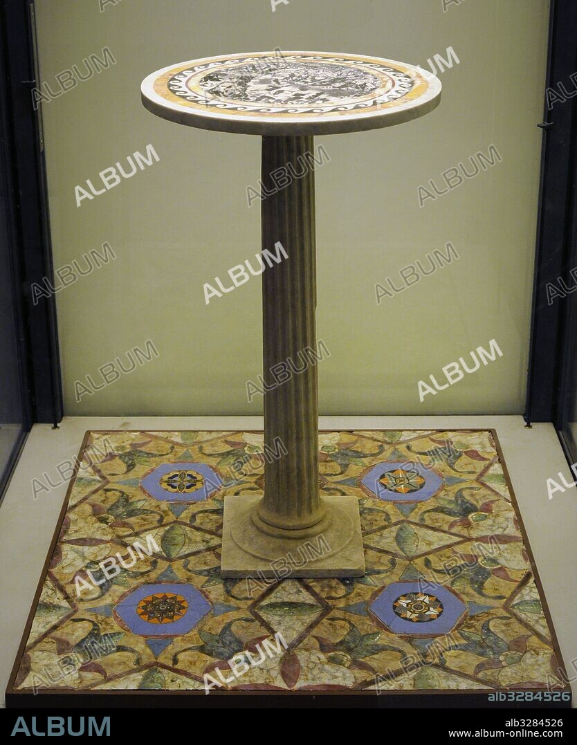 Arte romano. Pequeña mesa de mármol decorada con la técnica opus sectile, procedente de la Casa del Efebo (I 6, 11). Colocada sobre cuatro de las ocho placas hexagonales realizadas en pasta de vídrio azul del triclínio de la Casa de las Vestale (VI, 1, 7). Pompeya. Museo Arqueológico Nacional. Nápoles. Italia.