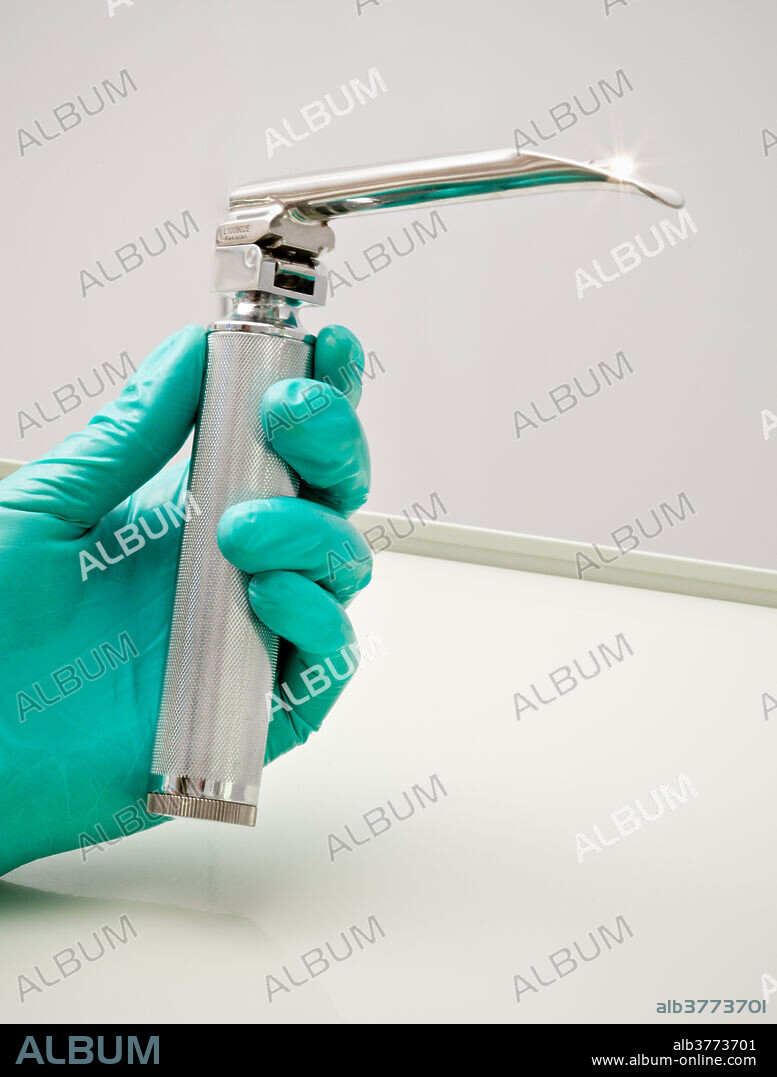 Laryngoscope with Miller blade. A laryngoscope is a rigid instrument used to examine the larynx and to facilitate intubation of the trachea. It is composed of two separate parts: the handle (which also contains the battery) and the blade, which is used to move the tongue and soft tissues aside to reveal a view of the larynx. An incandescent bulb can be found on the blade tip - it turns on when the blade is attached to the handle and locked into the 90 degree position to illuminate the larynx.