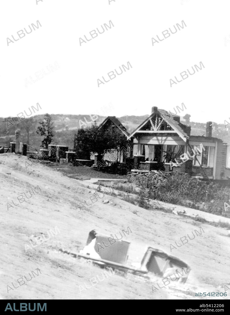 Rubble of houses after race riot. The Tulsa race riot of 1921 began over Memorial Day weekend after 19-year-old Dick Rowland, a black shoeshiner, was accused of assaulting Sarah Page, a 17-year-old white elevator operator. After he was taken into custody, a group of armed black men, worried about a possible lynching, rushed to the police station where they encountered a crowd of white men and women. Shots were fired, and 12 people were killed, 10 white and 2 black. Mob violence exploded. About 10,000 black people were left homeless, and property damage amounted to more than $1.5 million in real estate and $750,000 in personal property ($32 million in 2019). Alvin C. Krupnick Company, 1921.