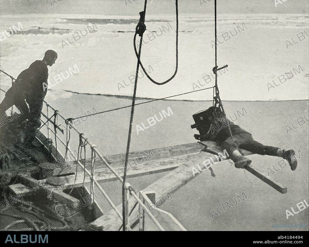 'Ponting Cinematographs The Bow of the 'Terra Nova' Breaking Through the Ice-Floes', c1910?1913, (1913). 'Camera artist' Herbert G Ponting (1870-1935) lies on planks to film the ship. The final expedition of British Antarctic explorer Captain Robert Falcon Scott (1868-1912) left London on 1 June 1910 bound for the South Pole. The Terra Nova Expedition, officially the British Antarctic Expedition (1910-1913), included a geologist, a zoologist, a surgeon, a photographer, an engineer, a ski expert, a meteorologist and a physicist among others. Scott wished to continue the scientific work that he had begun when leading the Discovery Expedition to the Antarctic in 1901-04. He also wanted to be the first to reach the geographic South Pole. Scott, accompanied by Dr Edward Wilson, Captain Lawrence Oates, Lieutenant Henry Bowers and Petty Officer Edgar Evans, reached the Pole on 17 January 1912, only to find that the Norwegian expedition under Amundsen had beaten them to their objective by a month. Delayed by blizzards, and running out of supplies, Scott and the remainder of his team died at the end of March. Their bodies and diaries were found eight months later. From Scott's Last Expedition, Volume I. [Smith, Elder & Co., London, 1913].