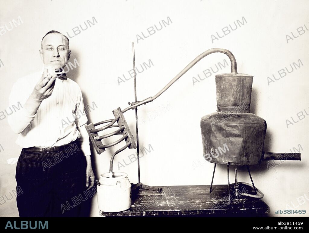 Entitled: "Moonshine still recently confiscated by the Internal Revenue Bureau photographed at the Treasury Department." Man standing next to still looking at contents of glass. Prohibition in the United States was a nationwide Constitutional ban on the sale, production, importation, and transportation of alcoholic beverages that remained in place from 1920 to 1933. It was promoted by dry crusaders movement, led by rural Protestants and social Progressives in the Democratic and Republican parties, and was coordinated by the Anti-Saloon League. Prohibition was mandated under the Eighteenth Amendment to the U.S. Constitution. Enabling legislation, known as the Volstead Act, set down the rules for enforcing the ban and defined the types of alcoholic beverages that were prohibited. Private ownership and consumption of alcohol was not made illegal under federal law; however, in many areas local laws were more strict, with some states banning possession outright. Nationwide Prohibition ended with the ratification of the Twenty-first Amendment, which repealed the Eighteenth Amendment, on December 5, 1933. National Photo Company circa, 1921-32.