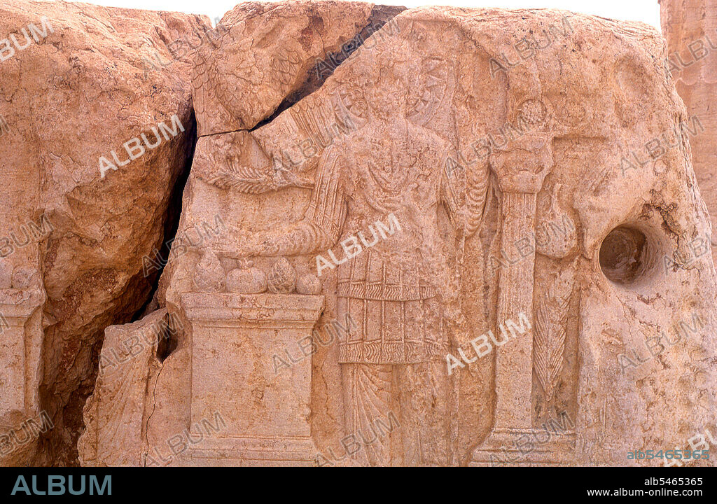 The Temple of Bel, consecrated to the Semitic god Bel, worshipped at Palmyra as Malakbel, formed the center of religious life in Palmyra and was dedicated in 32 AD. Palmyra was an ancient city in Syria. It was an important city in central Syria, located in an oasis 215 km northeast of Damascus and 180 km southwest of the Euphrates at Deir ez-Zor. It had long been a vital caravan city for travellers crossing the Syrian desert and was known as the Bride of the Desert. The earliest documented reference to the city by its Semitic name Tadmor, Tadmur or Tudmur (which means 'the town that repels' in Amorite and 'the indomitable town' in Aramaic) is recorded in Babylonian tablets found in Mari.
