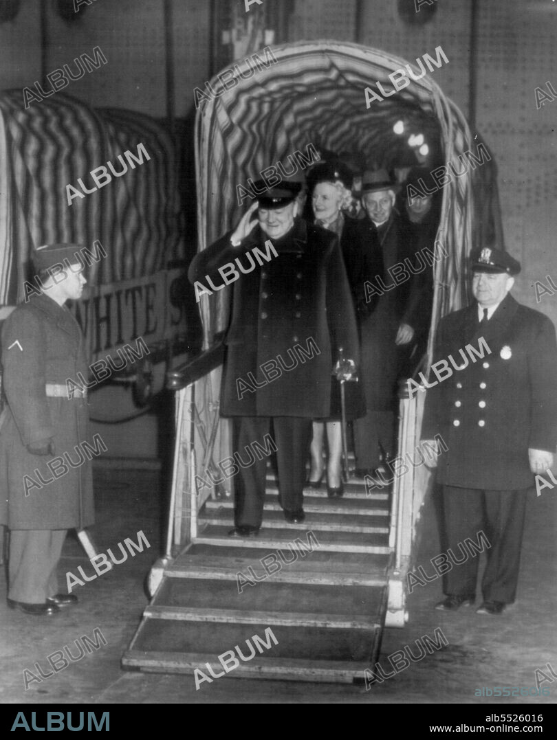 Churchill Arrive Aboard Queen Elizabeth : Winston Churchill, former British Prime Minister, salutes with a smile as he steps from a Gangplank after arriving here today Aboard The Liner Queen Elizabeth. Behind him is Mrs. Churchill. January 12, 1946. (Photo by AP Wirephoto).