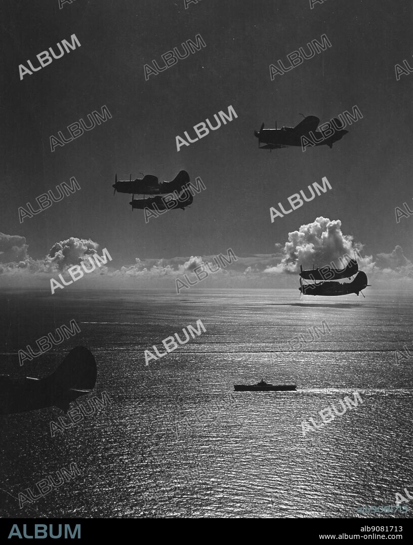 WW2: Silhouettes of SB2C S returning to a carrier of task force 58.1 from a bombing mission over Chicha-Jima in Bonin Islands. 600 miles south of Tokyo. Pacific warfare.