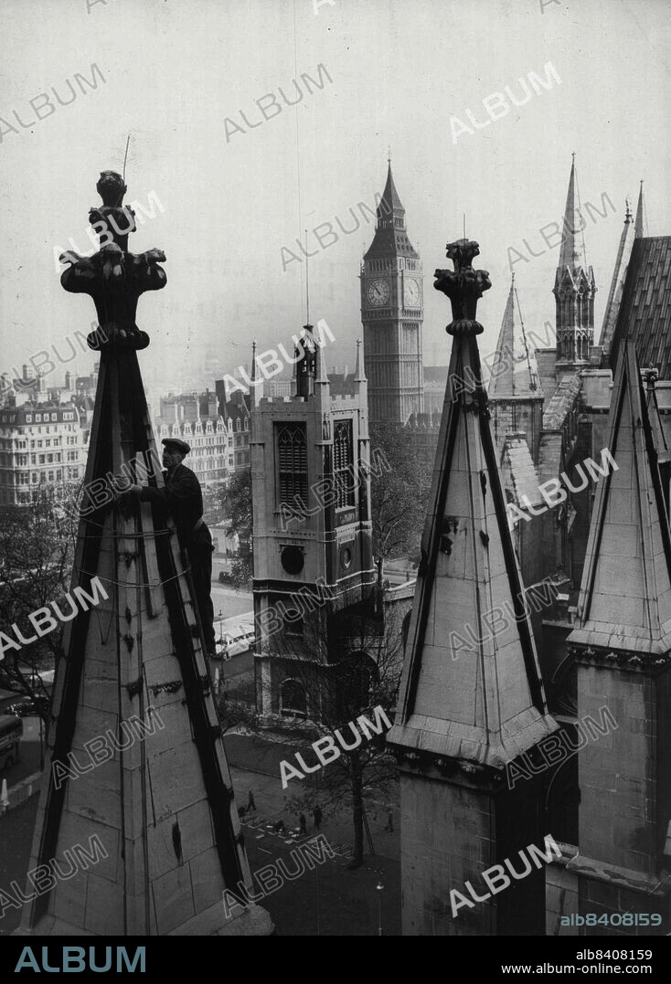180ft. Over Westminster-Splints for Abbey Pinnacle - Working on one of the pinnacles on the north side of Westminster Abbey, 180ft, above street level, to-day (Wednesday) is Mr. Albert Andrews of Kennington, London.The pinnacle, which is in a dangerous condition, is having to be put in splints to make it safe when the lawns of the Abbey become a Field of Remembrance at the Week-end-far below, crosses can be seen in the picture already being planted.The operation involves the erection of scaffolding to the top of the pinnacle and the securing of substantial timbers around the stonework to prevent any heavy fall of stone owing to a fracture near the summit. November 04, 1953. (Photo by Reuterphoto).