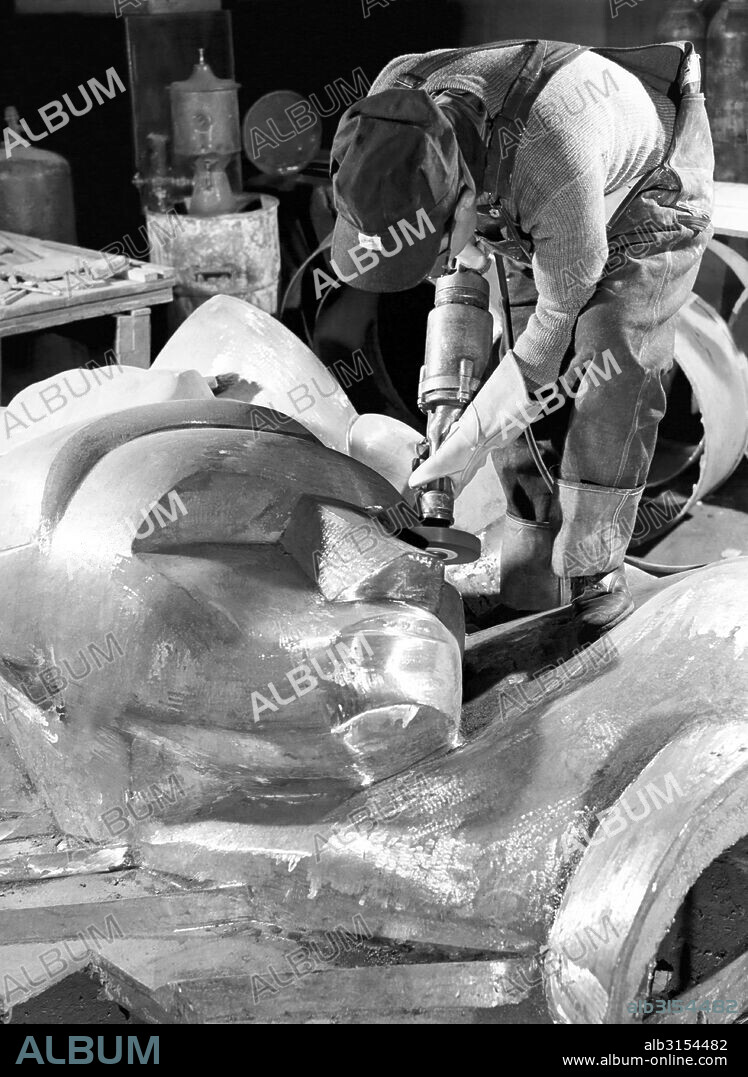 New York, New York:  1940 Isamu Noguchi working on the Associated Press Building Plaque, which was carved in plaster and cast in stainless steel - at that time the largest-ever stainless steel casting.  It is still installed in Rockefeller Center.