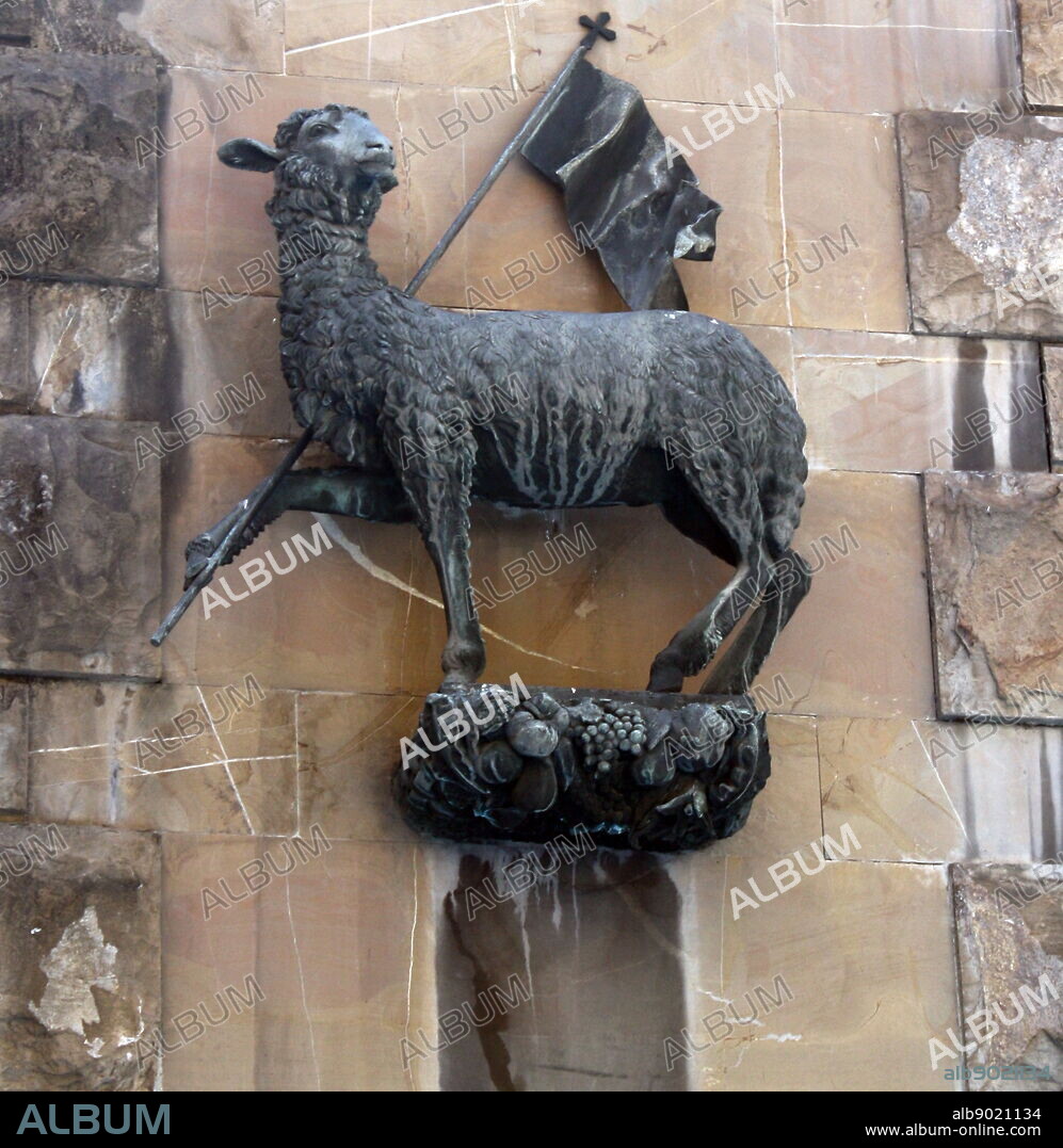 Statue detail on the outside of a church in Florence, Italy. Semi enclosed figurative statues such as this appear all over Florence. This is a statue of a sheep proudly holding a flag.