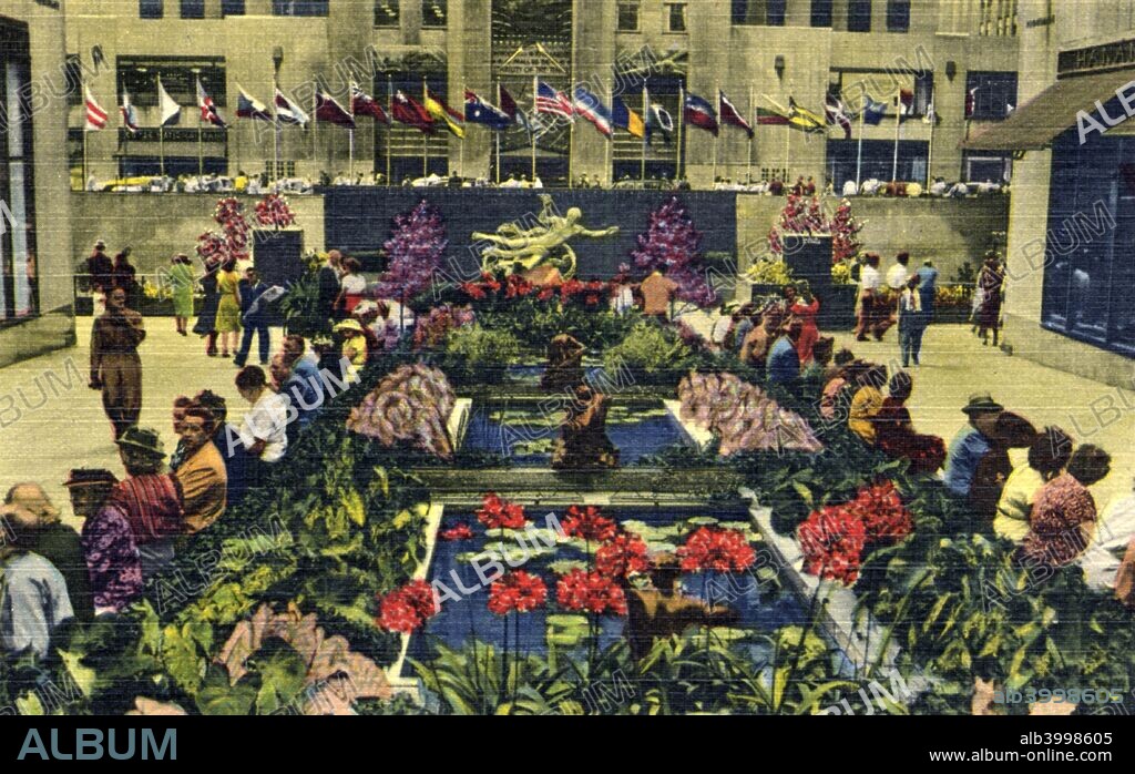 The Channel Gardens, Rockefeller Center, New York, 1951. Vintage linen postcard showing a midsummer view of the world famous Prometheus Fountain by Paul Manship, with flags of the United Nations in Rockefeller Plaza in the background. The Art Deco Rockefeller Center complex is made up of several buildings, fourteen of them built between 1931 and 1939. American industrialist John D Rockefeller (1839-1937) financed the project.