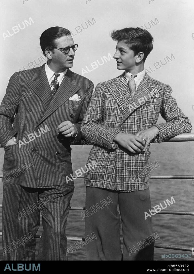 Orig. bildtext... GRETA GARBO'S PRODUCER ARRIVES. Stromberg, Metra-Goldwyn-Mayor producer, photographed with his son, Hunt Junior - a budding producer - on arrival at Plymmuth on the Queen Mary from New York, to find locations for a coming film of Robin Hood, the legendary English bandit of the Middle ages, starring Jeanette MacDonald and Nelson Eddy. Anm. Far och son Filmproducent Blicken Ansiktsuttryck sites: USA.