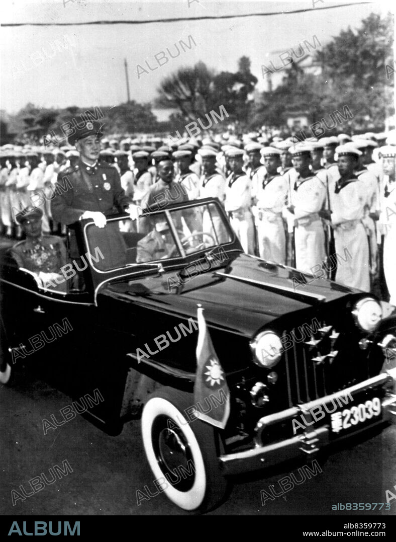 'Gissimo' Reviews His Naval Forces - Generalissimo Chiang Kai-Shek, President of Nationalist China, stands in his five-star Jeep as he reviews naval personnel at Taipeh, capital of Formosa. The naval forces are training under the mutual defense program. A bemedaled Chinese officer rides in rear seat. February 4, 1953. (Photo by Department of Defence photo).
