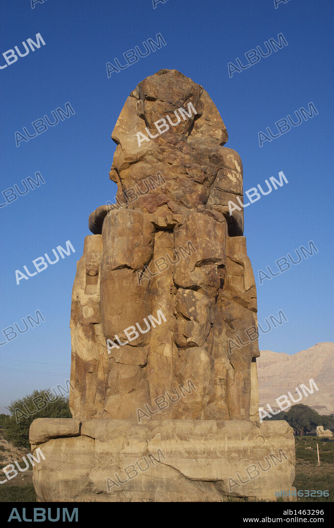 Colossi of Memnon. Stone statues depicting pharaoh Amenhotep III (14th century B.C.) in a seated position. Western colossus. Eighteenth Dynasty. New Kingdom. Luxor. Egypt.