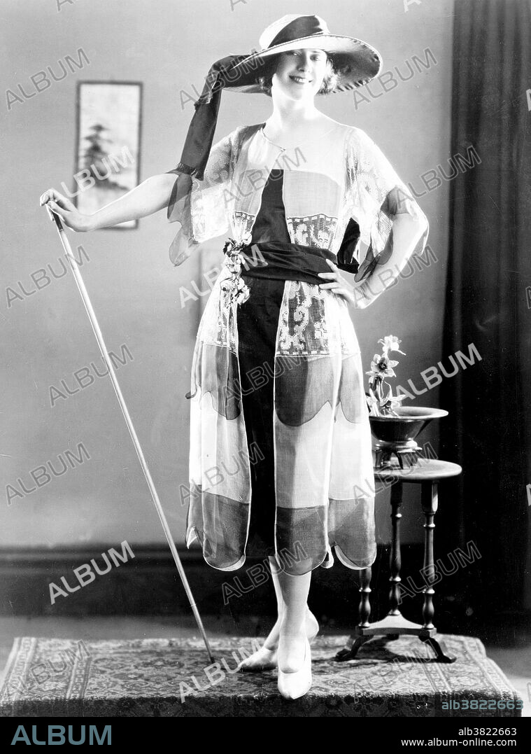 Woman's clothing being modeled at the spring fashion show of the National Retail Garment Association in the Hotel Commodore, New York City, 1921. Fashion is a popular style or practice, especially in clothing, footwear, accessories, makeup, or furniture. Fashion is a distinctive and often habitual trend in the style in which a person dresses. It is the prevailing styles in behavior and the newest creations of textile designers. Prior to the mid-19th century, most clothing was custom-made. It was handmade for individuals, either as home production or on order from dressmakers and tailors. By the beginning of the 20th century, with the rise of new technologies such as the sewing machine, the development of the factory system of production, and the emergence of department stores, clothing had increasingly come to be mass-produced in standard sizes and sold at fixed prices. Photographed by Underwood & Underwood, 1921.
