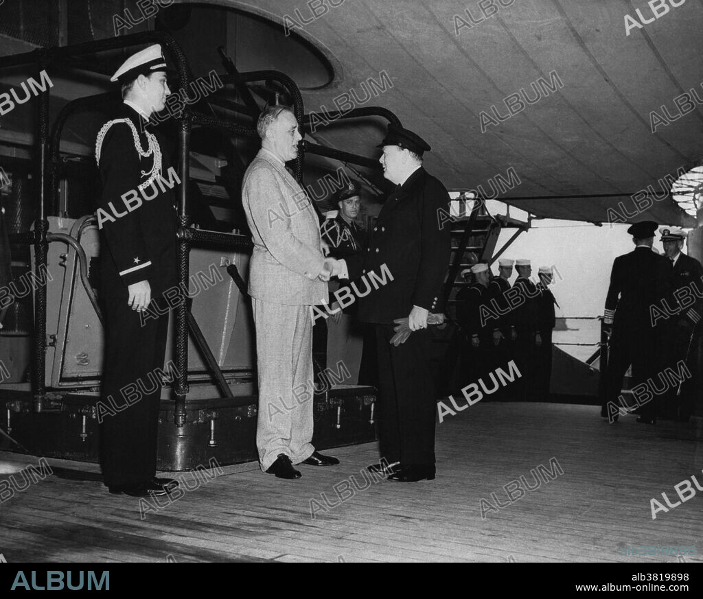 The Atlantic Conference ends as Winston Churchill says farewell to FDR and prepares to leave the USS Augusta; FDR Jr. can be seen at the left, and Elliott Roosevelt is visible in the background; Placentia Bay, Newfoundland, August 12th, 1941.