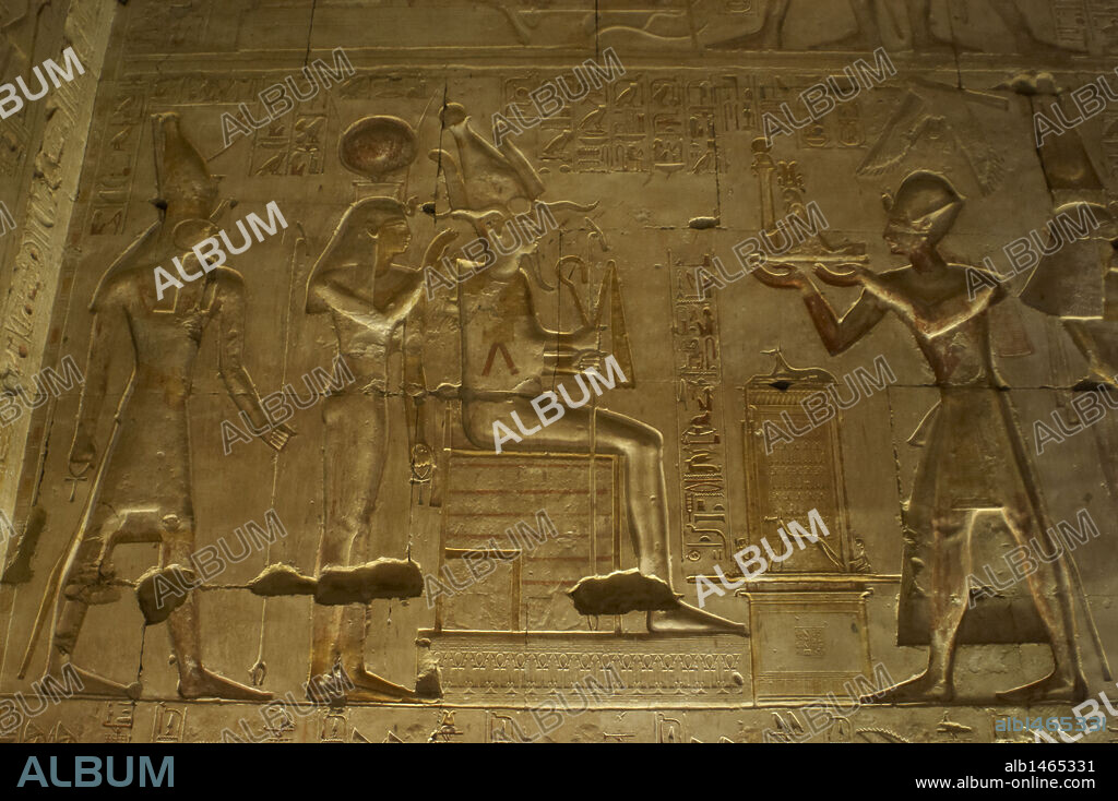 ARTE EGIPCIO. EGIPTO. TEMPLO DE SETI I en ABIDOS (ABYDOS). Mandado construir por el faraón de la Dinastía XIX del Imperio Nuevo, y terminado por su hijo Ramses II. Relieves con la representación de SETI I OFRECIENDO UNA ESTATUA DE MAAT A OSIRIS, ISIS Y HORUS. Abidos. Egipto. Norte de Africa.