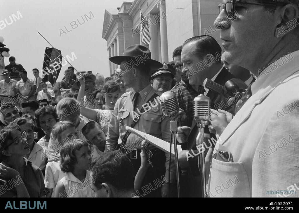 Little Rock, USA, 1959. Rally at state capitol. Photograph shows a group of people, one holding a Confederate flag, surrounding speakers and National Guard, protesting the admission of the Little Rock Nine to Central High School. 20 August 1959. Photographer: John T Bledsoe.