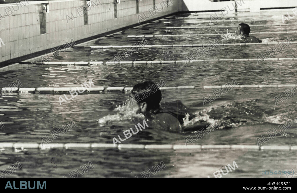 Racing for ***** at Meiji Shrine Pool.... Mr. Tetsuo Hamuro, near to the camera, is seen at learning in the 100 breast-stroke, in which Hamuro won the 1st place timed 1x13 ***** to the Japan record, today at the Meiji Shrine Pool, on the 3rd day of the 17th all-Japan student aquatic championship meet. September 18, 1938. (Photo by The Domei News Photos Service).