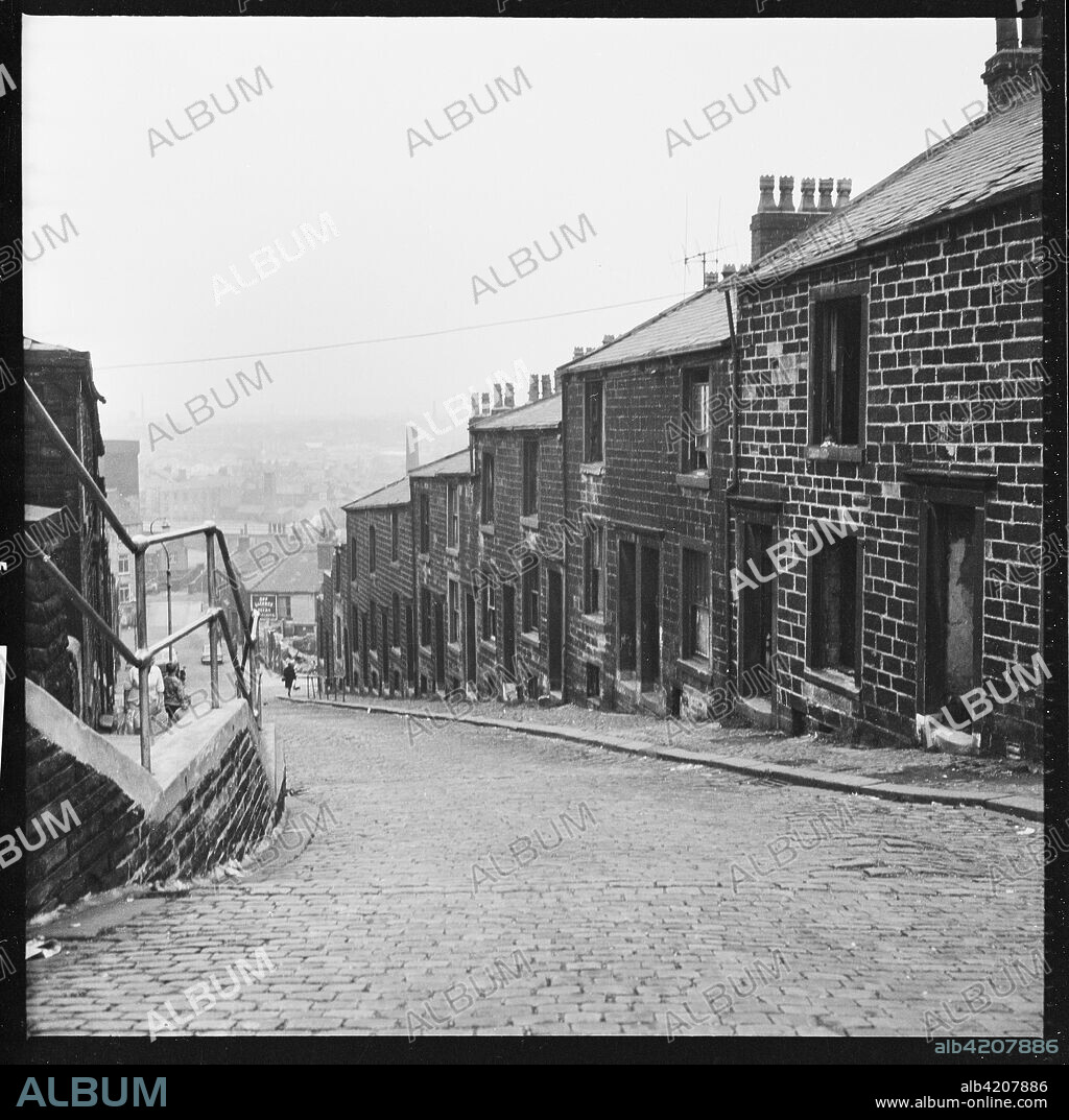 Healey Wood Road, Burnley, Lancashire, c1966-c1974. View looking north along the road from the railway line showing abandoned houses awaiting demolition.