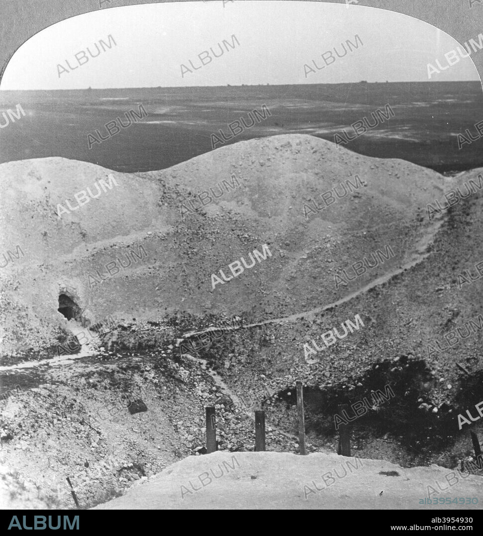 Mine crater at La Boiselle, the Somme, France, World War I, c1916-c1918. The crater was created by a massive underground mine placed in tunnels beneath the German lines by British sappers of the Royal Engineers. Known as the Lochnagar Mine, it was detonated on 1 July 1916 on the opening day of the Battle of the Somme. The crater has been preserved and is the site of a war memorial. Stereoscopic card detail.