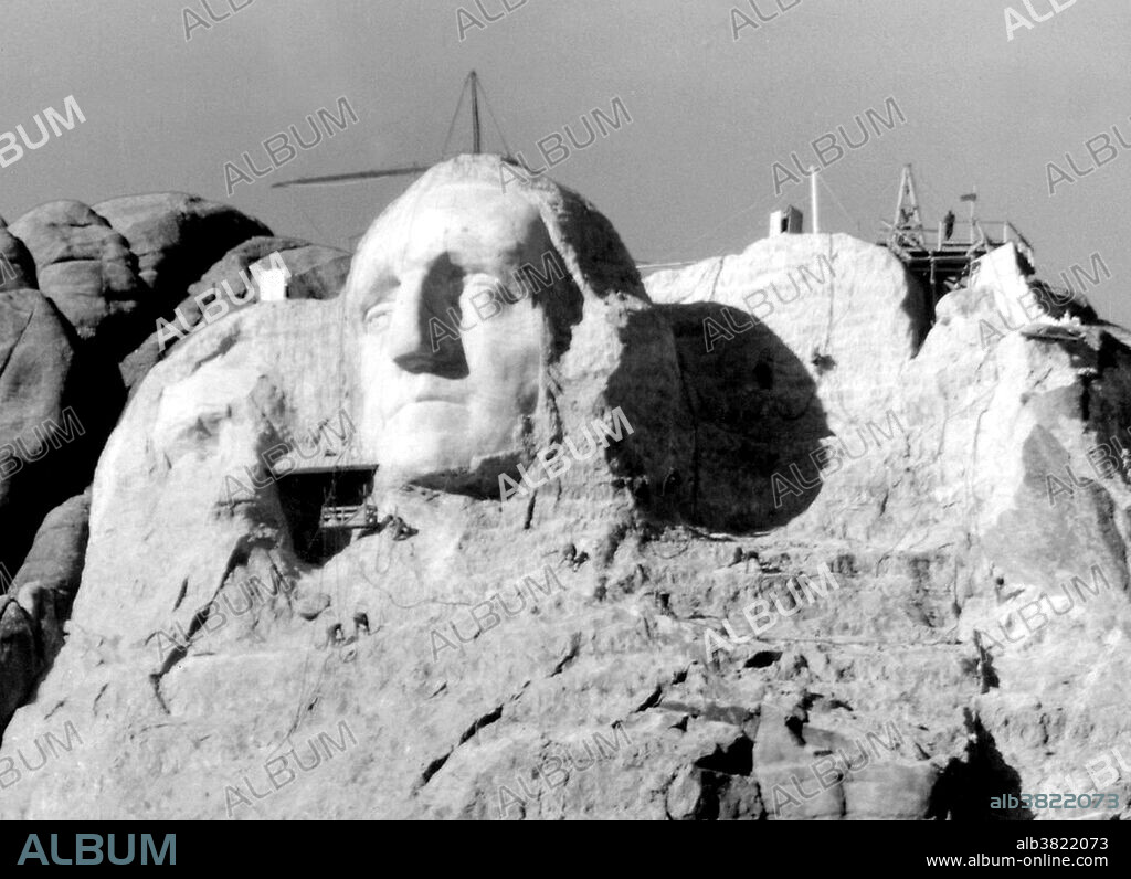 The first attempt at Thomas Jefferson on Mount Rushmore. Jefferson's head was started in 1934, to the right of Washington. Before the head was complete, Borglum requested that it should be blasted off due to poor rock quality. Jefferson's head was restarted on Washington's left. Mount Rushmore National Memorial is a sculpture carved into the granite face of Mount Rushmore near Keystone, South Dakota. Sculpted by Danish-American Gutzon Borglum and his son, Lincoln Borglum, Mount Rushmore features 60 foot sculptures of the heads of four United States presidents: George Washington, Thomas Jefferson, Theodore Roosevelt, and Abraham Lincoln. Construction on the memorial began in 1927, and the presidents' faces were completed between 1934 and 1939. Although the initial concept called for each president to be depicted from head to waist, lack of funding forced construction to end in late October 1941. Mount Rushmore has become an iconic symbol of the United States, and attracts over three million people annually. Photographed by Charles D'Emery, undated.