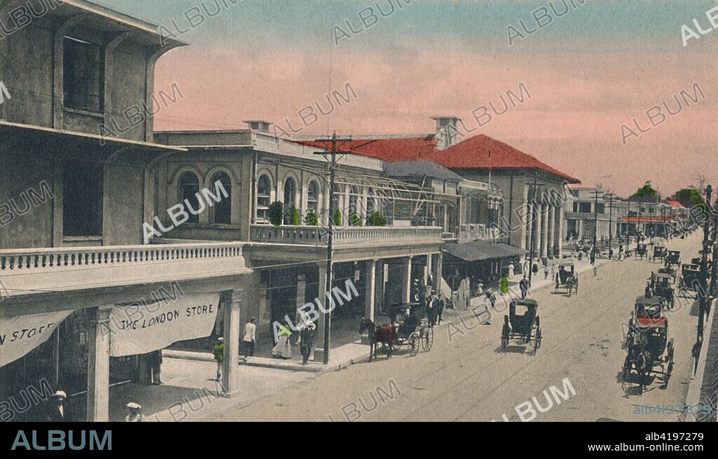 'King Street, looking north, Kingston, Jamaica', early 20th century. Street scene with horse-drawn carriages, and 'The London Store' on the left.