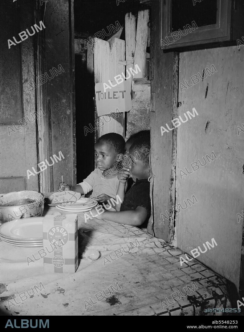 GORDON PARKS. Washington, D.C. Three children waiting in the kitchen while their mother prepares the evening meal.