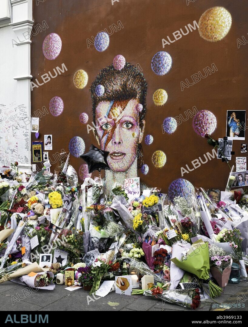 Tribute to David Bowie, Tunstall Road, Brixton, London, January 2016. Flowers and tributes surround the mural of pop star David Bowie after his death. The mural was painted by Australian street artist James Cochran (aka Jimmy.C) in 2013.
