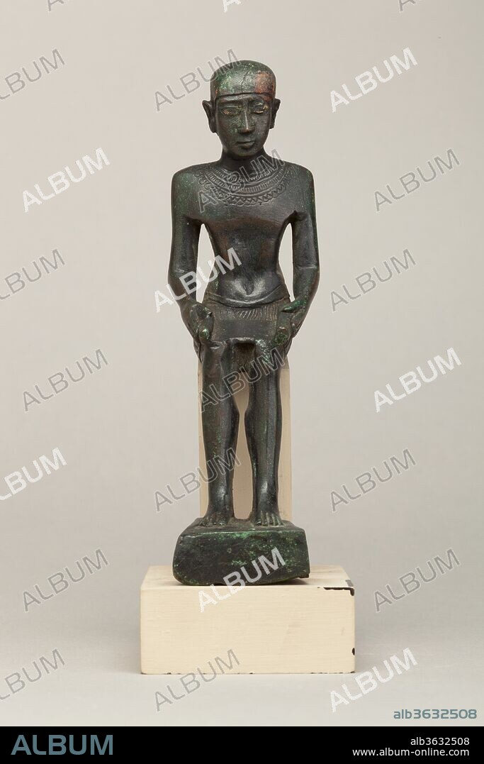 Imhotep. Dimensions: H. 16.2 cm (6 3/8 in.); W. 4.8 cm (1 7/8 in.); D. 7.7 cm (3 1/16 in.)
H. (with tang): 18.1 cm (7 1/8 in.). Date: 664-30 B.C..
Imhotep was adviser to King Djoser in the third dynasty and he is credited with the design of the Step Pyramid in Saqqara, the earliest pyramid in Egypt. For this and other achievements of wisdom and learning attributed to him, in later periods he became one of the only historical non-royal people to be divinized and to have a dedicated cult, which was particularly strong in the Memphite region. In copper alloy statuettes like this one, he is shown sitting, wearing his close-fitting cap and holding a scroll on his lap. Imhotep's scroll serves to emphasize his wisdom and erudition, his role as a patron of scribes, and hints at the many intellectual forays into medicine, architecture, and engineering that were later ascribed to him. His eyes are gilded, which gives him a piercing look, and his facial and bodily features are well defined, if somewhat angular on the upper body. His attire varies, but in this instance he wears a broad collar that is articulated on the front and back of his chest and a short kilt.