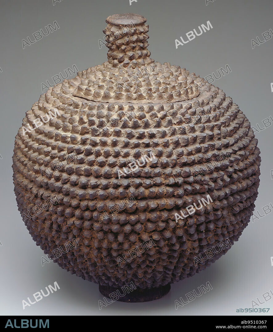 Jar with lid, mid 20th century, 18 x 14 in. (45.72 x 35.56 cm), Clay, Burkina Faso, 20th century, The spikes on this jars surface line up in tight rows, looking like the helmets of a well-organized army. Indeed, the spikes symbolize defense against illness, misfortune, and duntundara (evil forces, which in English would translate as 'witchcraft'). Vessels like this were placed on altars dedicated to a protective spirit, and they contained water or powerful medicines destined for that spirit. The lid, which is smoothly integrated into the pots pod-like form, protected its contents from natural and supernatural contamination.