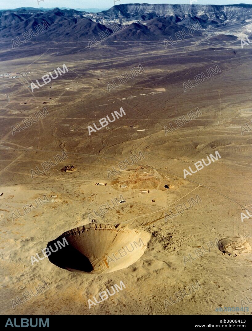 Storax Sedan, an underground 100-kiloton thermonuclear test conducted at Nevada Test Site on July 6, 1962 as part of Operation Plowshare, was a program designed to develop peaceful uses for nuclear explosives, such as canal and harbor building. Sedan left the largest man-made crater in the United States, displacing 12 million tons of earth and measuring 320 feet deep by 1280 feet in diameter. A circular area was leveled at the bottom of the crater to stop earth that might slide into the center, where sample drilling began eight months after the detonation.