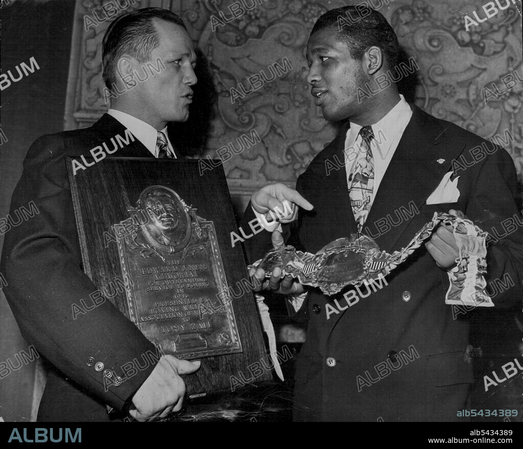 Receive Awards From Boxing Writers -- Tony Zale (left), middle weight boxing champion, holds the Edward J. Neil Plaque and Ray (Sugar) Robinson. welterweight champ, holds a belt Awarded Jan.22 at the annual dinner of the Boxing writers Association of New York city. The Neil award was made in memory of Edward J. Neil, Associated Press boxing writer and war correspondent, killed in the Spanish revolution. The belt held by Robinson was awarded by Ring Magazine. January 22, 1947. (Photo by Associate.