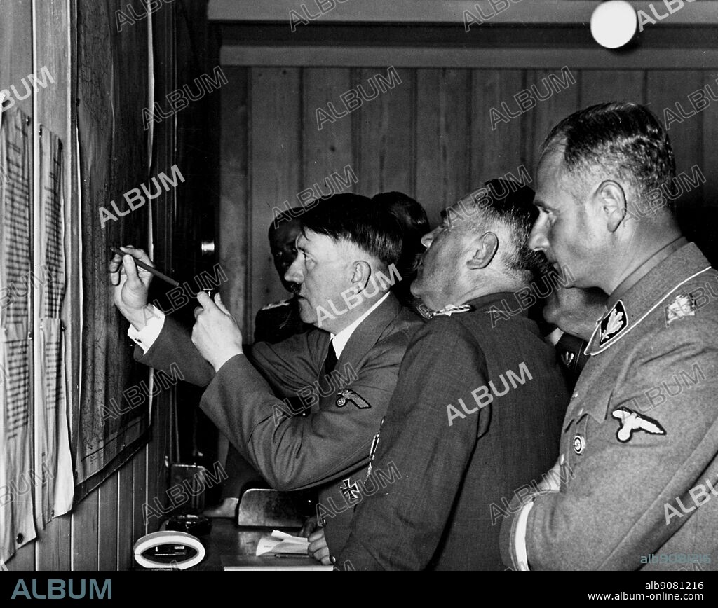 Austrian-born Nazi leader, Adolf Hitler and other officers study a map.