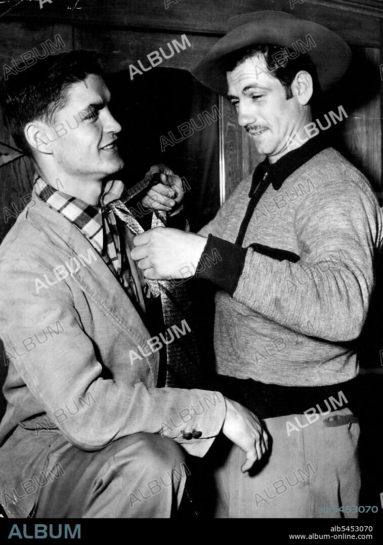 "I'm Not Much Good At This," says Bronco Don Johnson as he tries to knot a tie for his friend American bantam Johnny O'Brieri Johnson, who fights Len Dittmar at Sydney Stadium tomorrow night, says he has only worn a tie once-at his wedding. April 27, 1952.